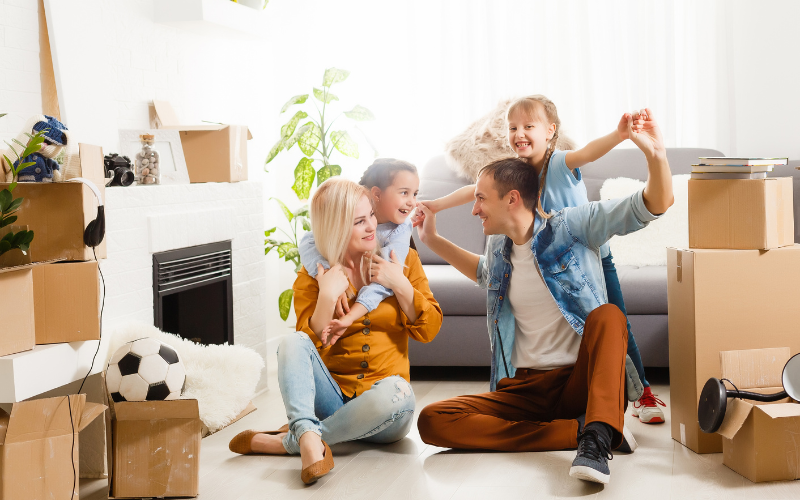 Happy family unpacking boxes in their home after exploring the Leaseback Option with JAAG Properties